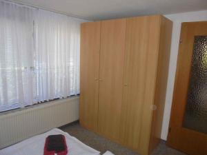 WartheApartment in Rankwitz OT Warthe 34765的卧室设有大型木制橱柜,靠窗