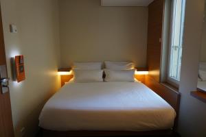柏林柏林哈克市场便捷酒店的一间卧室配有一张带白色床单的床和一扇窗户。