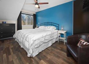 坎莫尔Mountain Gate - Pet Friendly 2BR w Mountain Views and open hot tub的一间卧室设有一张床和蓝色的墙壁
