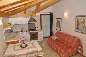 皮耶韦迪莱德罗Apartments in Pieve di Ledro/Ledrosee 22671的一间带红色沙发的客厅和一间厨房