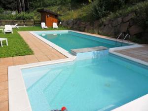 皮耶韦迪莱德罗Apartments in Pieve di Ledro/Ledrosee 22671的一个带两把白色椅子的庭院内的游泳池