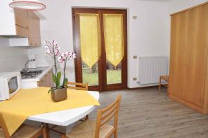 莱德罗Apartments in Pieve di Ledro/Ledrosee 22632的厨房以及带桌子和黄色桌椅的用餐室。