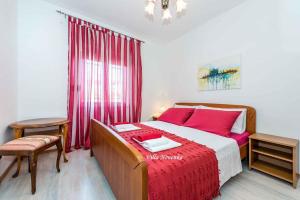 扎格拉维奇Apartment Rogoznica/Sibenik Riviera 7187的一间卧室配有一张带红色床单的床和一扇窗户。