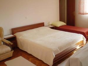 坎普尔Kampor Apartment 3的一间小卧室,配有一张床和一把椅子