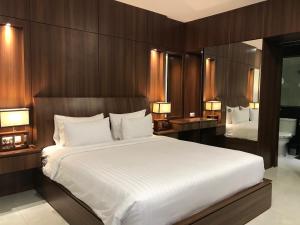 CitujaRozelle by d'best hospitality的卧室配有一张白色大床和两盏灯。