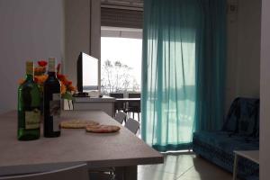 罗索利纳马雷Two-Bedroom Apartment Rosolina Mare near Sea 3的客厅配有一张桌子和两瓶葡萄酒