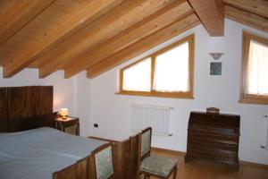 莱德罗Holiday home in Pieve di Ledro 22670的一间卧室配有一张床、一个梳妆台和两个窗户。