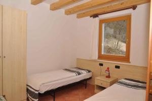 莱德罗Holiday home in Pieve di Ledro 22670的带窗户的客房内的两张床
