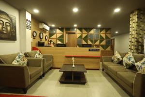 西里古里VIPs Hotel Olive的客厅配有两张沙发和一张咖啡桌