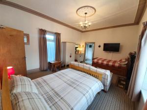 巴里港Caulfields Hotel的酒店客房设有两张床和电视。