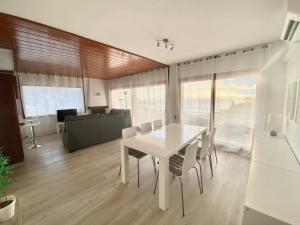 滨海托萨Apartamento Tossa de Mar的一间配备有白色桌椅的用餐室