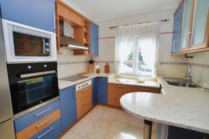 伊斯拉Apartamento Ama - 5828的厨房配有蓝色橱柜和桌子