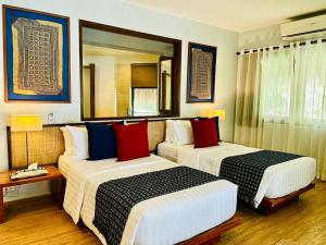 安达阿蒙依尼海滩度假和水疗酒店的酒店客房,设有两张床和镜子