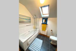 康多纳3 Bedroom House located in Centre of Carndonagh的带浴缸、卫生间和盥洗盆的浴室