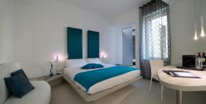 米兰多莫公寓酒店的一间卧室配有一张床、一张桌子和一张书桌