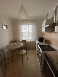 阿卢克斯内Apes ielas apartaments的一间带桌子的厨房和一间带桌椅的小厨房