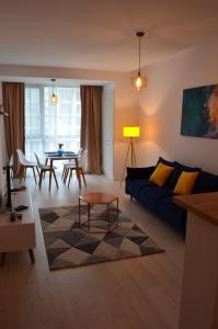 北马马亚-讷沃达里Aba's Apart Onix Blue Mamaia Nord的客厅配有蓝色的沙发和桌子