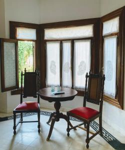 拉马约Posada Los Angelos的窗户间配有一张桌子和两把椅子