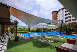 呵叻Kwanruen Resort的一个带桌椅的庭院和一个游泳池