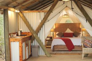 维德尼斯Heritage Glamping, Woodlands tent的帐篷内的卧室,配有一张床和一张书桌