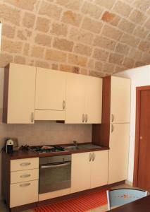 滨海波利尼亚诺Dimora Nonna Sisina的厨房配有白色橱柜和炉灶。