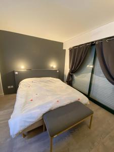 Saint-André-des-EauxAppartement Golf International de la Baule的卧室配有一张床铺,靠窗边设有长凳