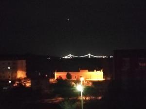 埃杰阿巴德Bahçeli Konak的一座城市,在夜晚,有一座桥在后面