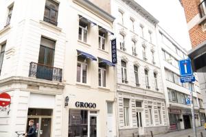 安特卫普GROGO DUPLEX APPARTMENT(CENTRE OF ANTWERP)的站在白色建筑前面的女人