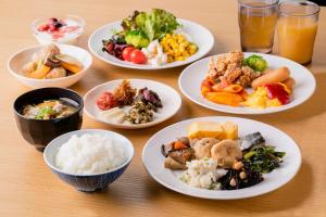 京都Hotel Wing International Premium Kyoto Sanjo的餐桌,盘子上放着食物和碗