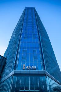 广州广州环贸中心越秀星廷公寓-广交会免费穿梭巴士的一座高大的玻璃建筑,上面有标志