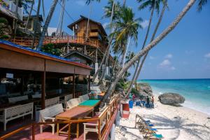 沙璜弗莱迪斯萨代萨莫提加度假酒店的海滩上的餐厅,种有棕榈树,享有海景