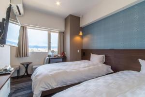 京都Meldia Stay Nijojo的一间卧室设有两张床和蓝色的墙壁