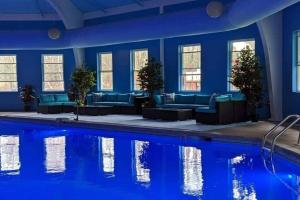 Long PondLovelyHouse!Escape&Nature!HiSpeedInternet!的客房设有带蓝色墙壁和沙发的游泳池。