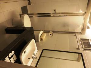 马尼拉西尔弗欧克斯套房酒店的浴室配有白色卫生间和盥洗盆。