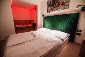 卢布尔雅那Dragons Dream Hostel的卧室设有一张白色大床和绿色的墙壁