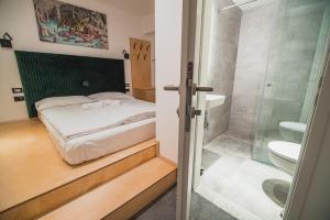 卢布尔雅那Dragons Dream Hostel的一间卧室配有一张床,浴室设有淋浴。