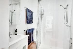 Cape WoolamaiModern 3 bedroom apartment, beach, surf & shops的带淋浴和盥洗盆的白色浴室