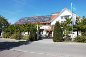 腓特烈港Hotel Wirtshaus Krone的顶部设有太阳能电池板的房子