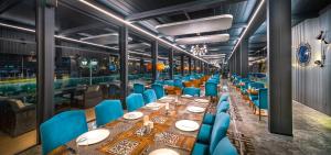 安卡拉Grand Mercure Ankara的一间带长桌和蓝色椅子的用餐室