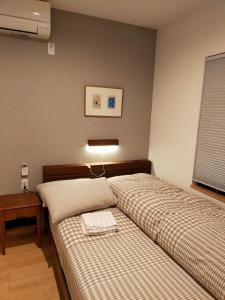 奈良Deer hostel- - 外国人向け - 日本人予約不可的一间卧室配有两张床、一张桌子和一盏灯。