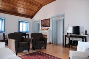 Azoia de BaixoAzoia 10 - Casas de Campo & Hostel的客厅配有两把椅子和钢琴