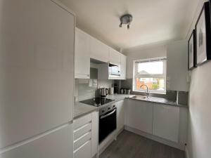 海维康Saffron Court by Wycombe Apartments - Apt 12的白色的厨房配有白色橱柜和水槽