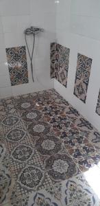 Sīdī ash ShammākhDar Mamina的浴室铺有瓷砖地板,设有淋浴。