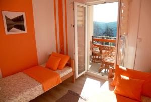 谢尼察Biserna Dolina Uvac的一间卧室设有橙色的墙壁、一张床和一个阳台