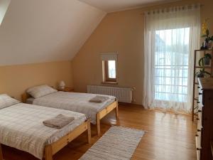 KavariPie Ezerrozēm的一间卧室设有两张床和大窗户