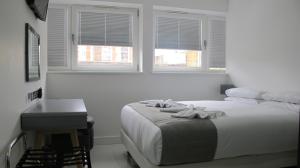 伦敦BLOOMSBURY APARTMENTS的白色卧室设有床、桌子和窗户