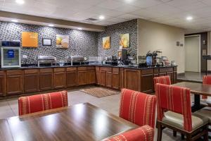 帕迪尤卡Comfort Inn Paducah I-24的一间带柜台和桌椅的餐厅