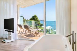 圣埃乌拉利亚ME Ibiza - The Leading Hotels of the World的客厅设有浴缸,享有海景