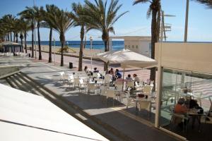 阿尔么丽亚Hostal Delfin Verde的一群人坐在海滩附近的餐馆里
