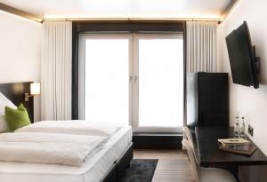 凯撒斯劳滕KL Hotel by WMM Hotels的一间卧室配有一张床、一台电视和一个窗口